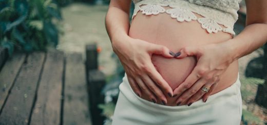 Pregnant Woman Wearing White Skirt Holding Her Tummy